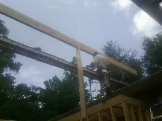 Carpenter setting a ridge beam over a new addition frame — Ice Dam Removal by Roofing Brothers in Hanover Park
