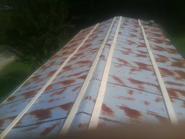 Rusted metal roof panels with new wood purlins before replacement — Storm Damage Roof Repair in Hanover Park by Roofing Brothers