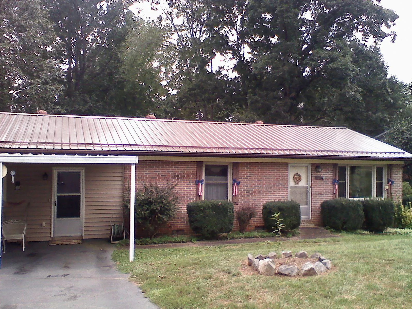 Bronze metal roof and carport on a brick ranch home — Roof Repair work by our crew in Hanover Park